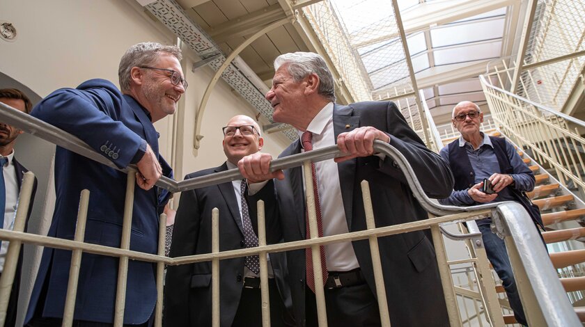 Oberbürgermeister Sven Schulze (Bildmitte) und Bundespräsident a.D. Joachim Gauck im Gespräch mit einem Zeitzeugen (links) im Kaßberggefängis.